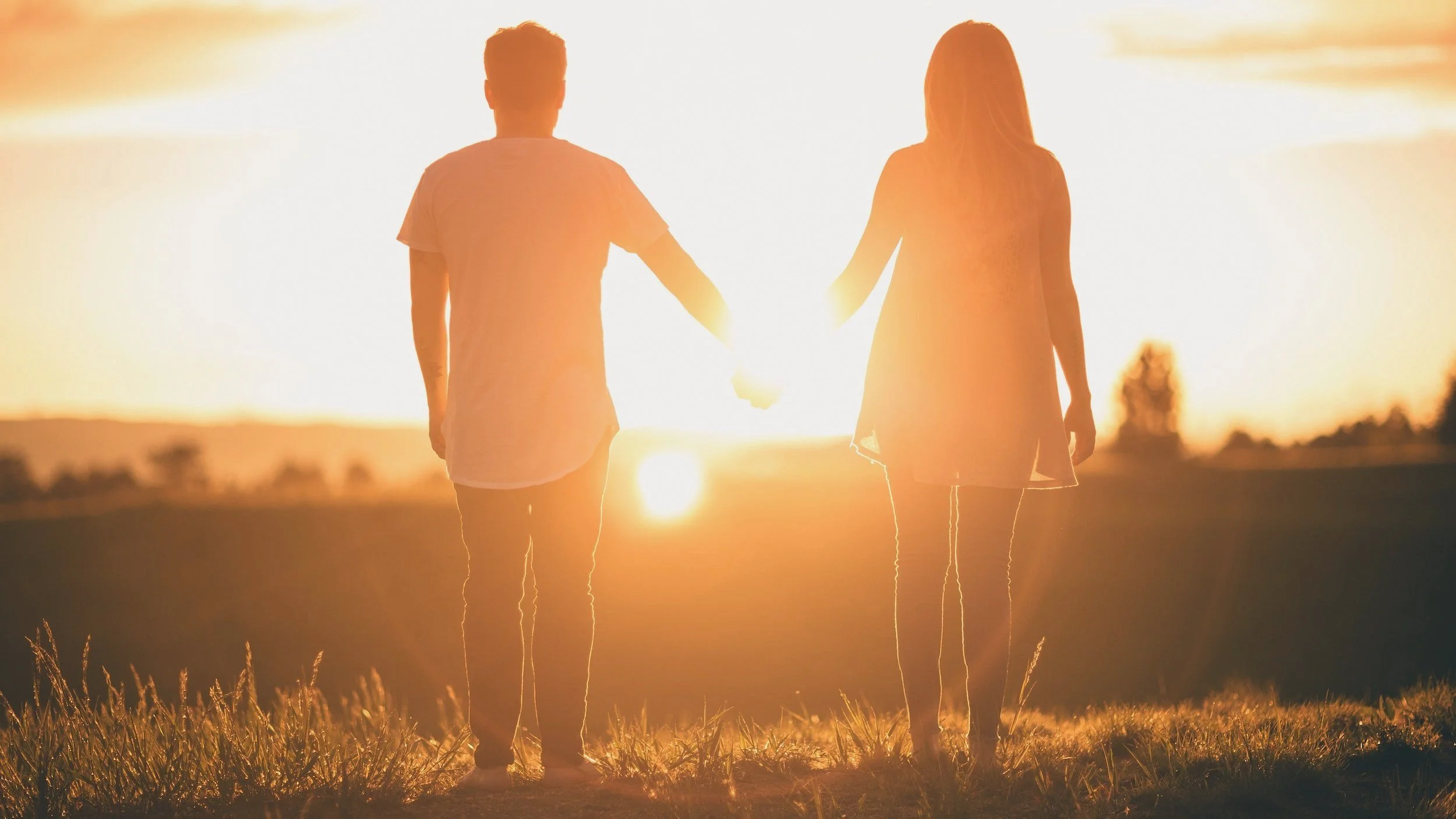 Couple walking on the beach at sunset